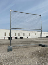Chain link temporary fence panel with steel frame and weighted bases, ideal for construction sites and event security.